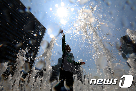 서울의 낮 최고기온이 36도를 기록하는 등 연일 폭염이 이어지고 있는 21일 오후 서울 광화문광장 분수대를 찾은 아이들이 물놀이를 하며 더위를 식히고 있다. / 뉴스1