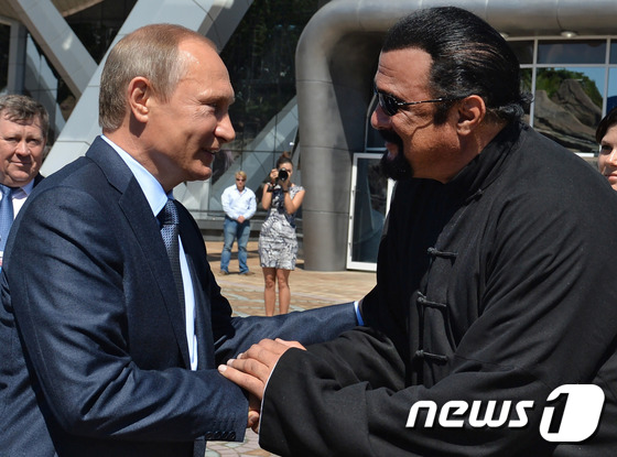 2015년 동방경제포럼 당시 블라디미르 푸틴 러시아 대통령(왼쪽)과 손을 잡고 있는 스티븐 시걸의 모습. / AFP=뉴스1