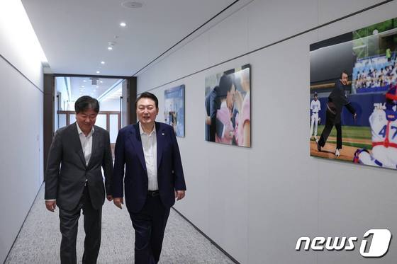 윤석열 대통령과 김대기 대통령 비서실장이 윤 대통령의 미국 국빈 방문, G7 정상회의 등 외교 활동과 일상을 담은 사진 8장이 게시된 대통령 집무실 복도를 걷고 있다.