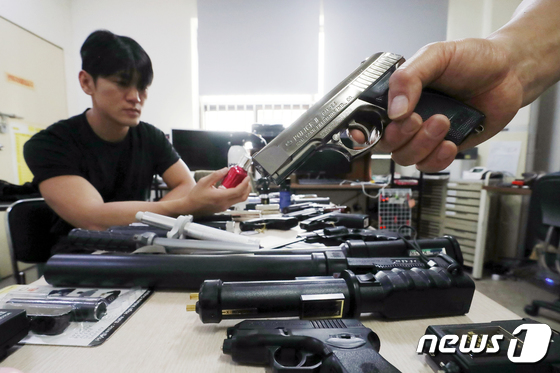 서울 구로구 금융안전관리공사 사무실에서 직원들이 가스총 등 호신용품을 선보이는 모습. / 뉴스1
